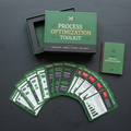 Premium workflow card deck flatlay with process symbol cards and companion guide on a dark surface